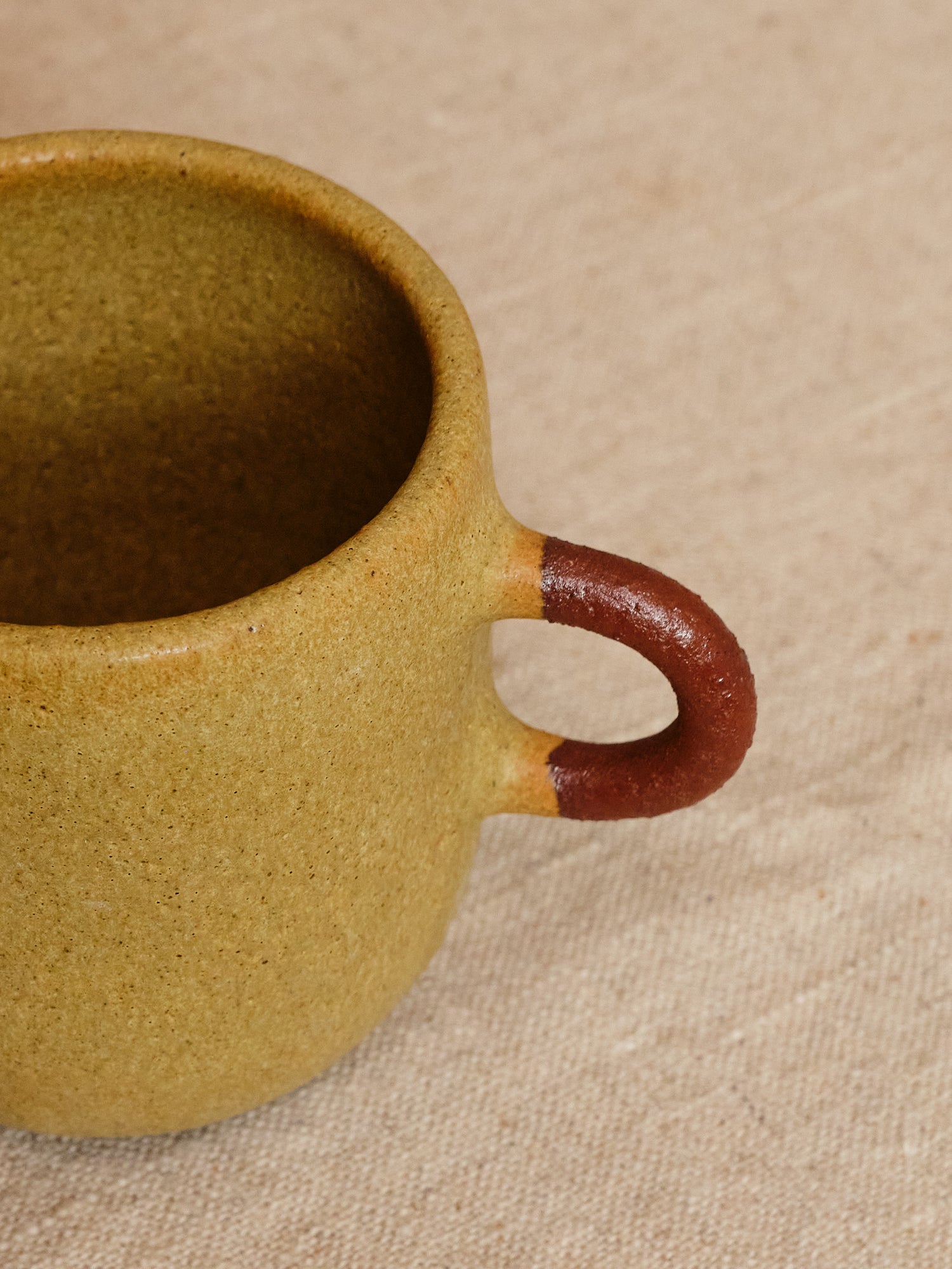 Ceramic mug with a brown handle on a beige background