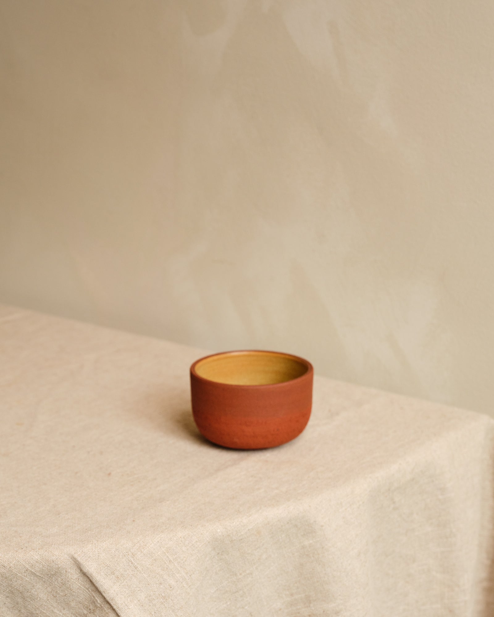 Small bowl on a beige surface with a plain background