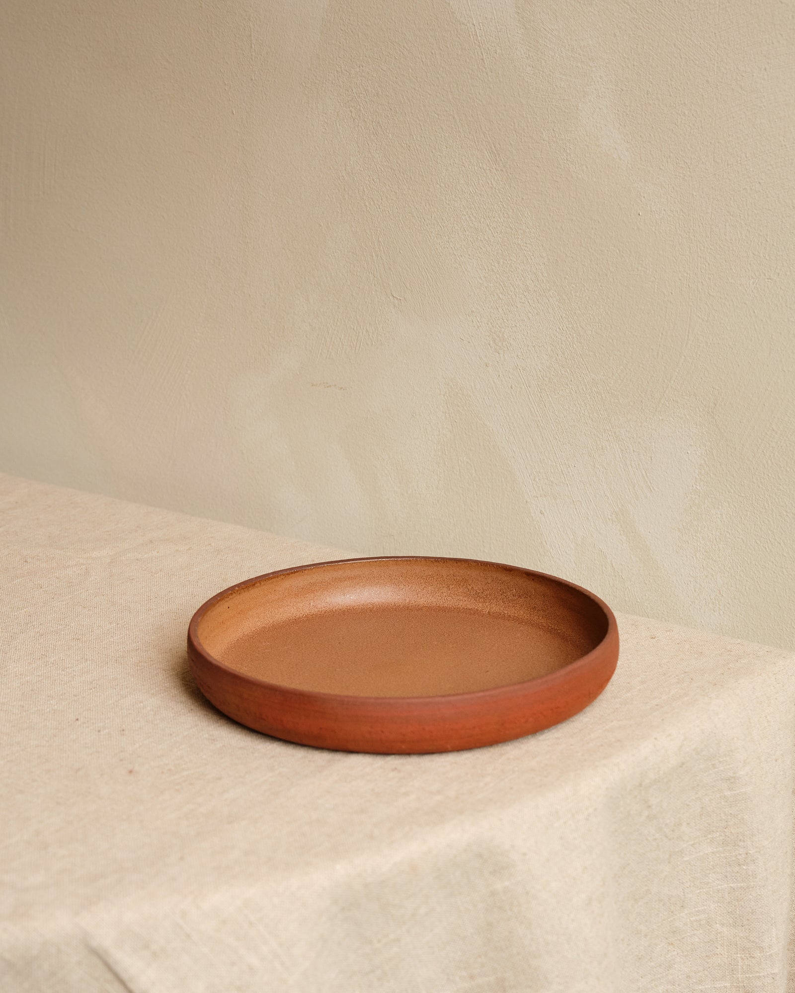 Ceramic plate on a textured beige surface with a neutral background