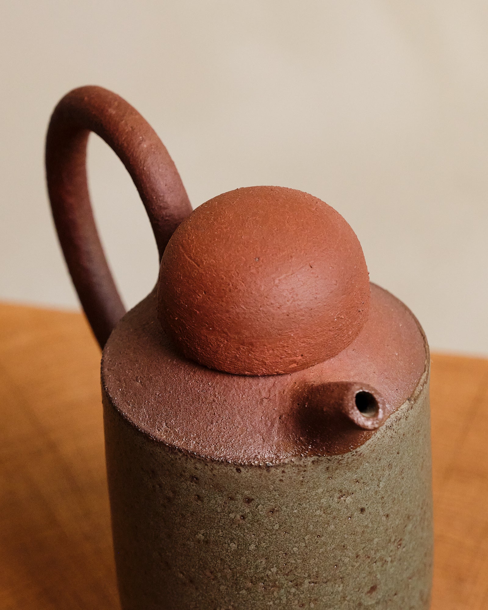 Ceramic bottle with a spherical lid on a wooden surface