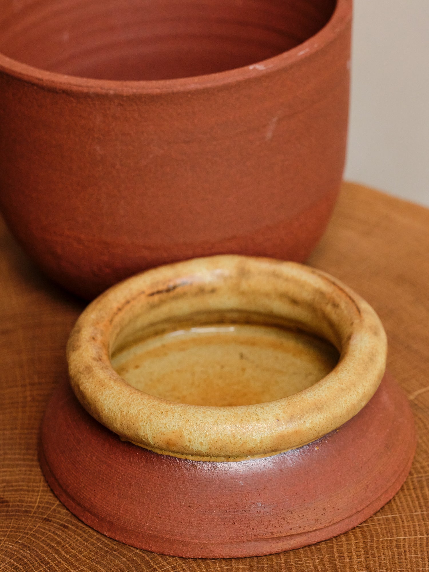 Two terracotta pots on a wooden surface
