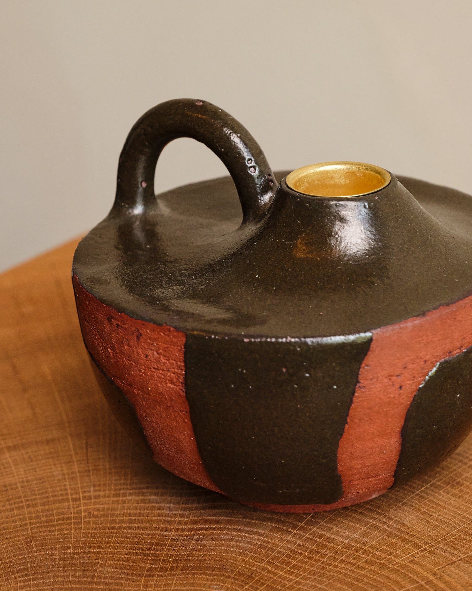 Ceramic vase with a handle on a wooden surface
