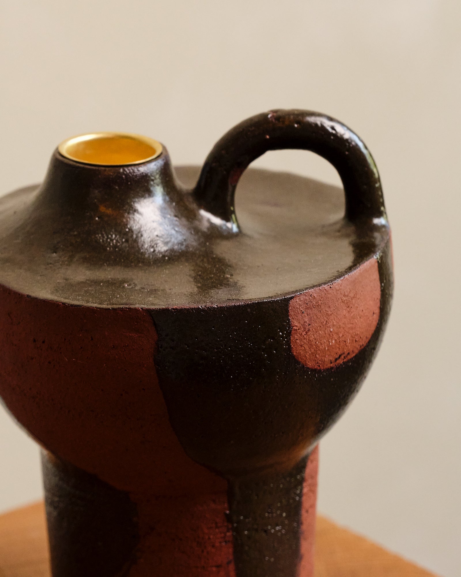 Ceramic vase with black and red design on a neutral background